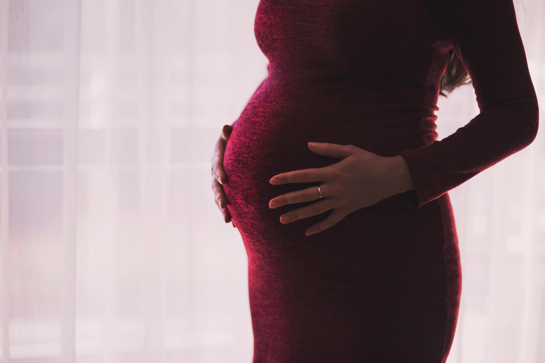 Maternity portrait of an expecting mother cradling her belly